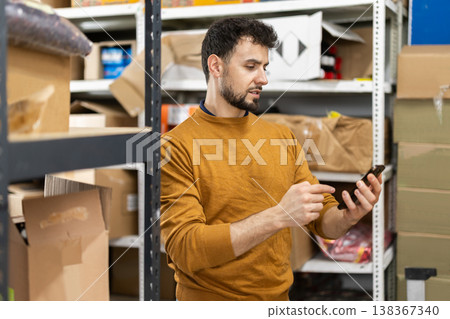 Young man scanning boxes in grocery warehouse Young man scanning boxes in grocery warehouse 138367340