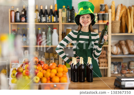 Positive friendly girl seller in traditional green Irish cap offers to buy Irish ale for St. Patrick Day celebration Positive friendly girl seller in traditional green Irish cap offers to buy Irish ale for St. Patrick Day celebration 138367350