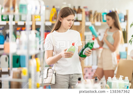 Young woman chooses dishwashing detergent in store 138367362