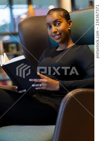 Student reading a book at library Student reading a book at library 138367371