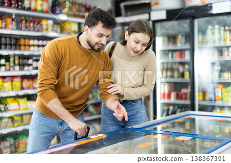 Young couple choosing frozen food in grocery store Young couple choosing frozen food in grocery store 138367391
