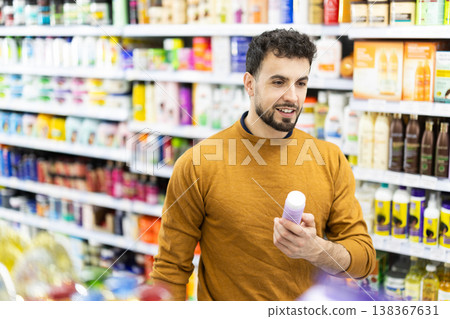 Man spends time in store, looking for goods and select care product 138367631