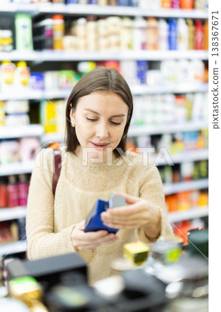 Young woman chooses perfume in store 138367671