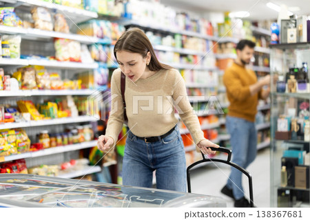 Young woman choosing frozen food in grocery store 138367681