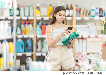 woman scans a package of detergent on her phone woman scans a package of detergent on her phone 138367683