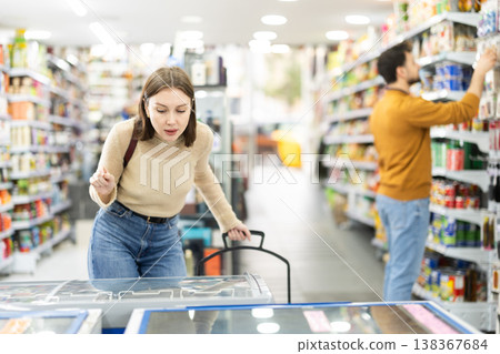 Young woman choosing frozen food in grocery store 138367684