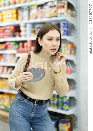 Girl in supermarket search and select product tin can Girl in supermarket search and select product tin can 138367707