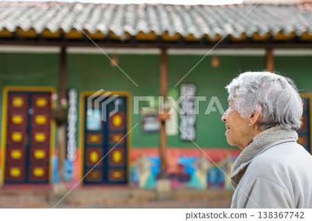 Happy senior lifestyle concept. Senior woman at the central square of the beautiful small town of Raquira. The city of pots in Colombia. Happy senior lifestyle concept. Senior woman at the central square of the beautiful small town of Raquira. The city of pots in Colombia. 138367742