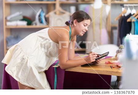 Woman dressmaker drawing on tablet Woman dressmaker drawing on tablet 138367870