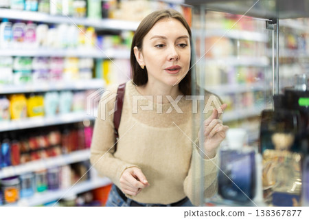 Young woman chooses perfume in store Young woman chooses perfume in store 138367877