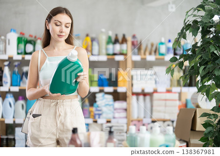 Woman looking for trademark sign on label, chooses eco friendly liquid powder Woman looking for trademark sign on label, chooses eco friendly liquid powder 138367981