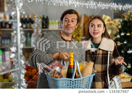 Husband and wife buy groceries at the supermarket for upcoming Christmas celebration Husband and wife buy groceries at the supermarket for upcoming Christmas celebration 138367987