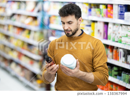 Man spends time in store, looking for goods and select care product Man spends time in store, looking for goods and select care product 138367994