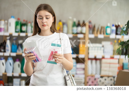Young woman choosing razor in store Young woman choosing razor in store 138368018