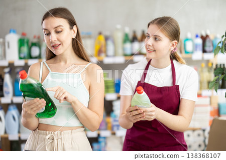 Sales girl offers woman choose dishwashing in household supermarket Sales girl offers woman choose dishwashing in household supermarket 138368107
