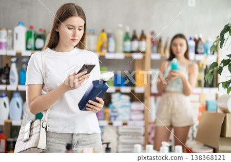 Girl scanning spray barcode on her phone Girl scanning spray barcode on her phone 138368121