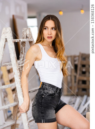 Young beautiful woman poses on a construction site Young beautiful woman poses on a construction site 138368126