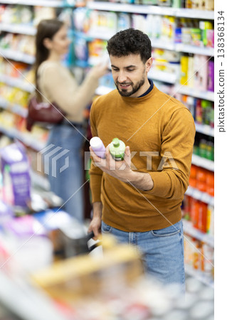 Male shopper is shopping in a supermarket, buying body care products 138368134