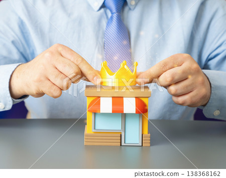 A man places a golden crown on a business. Recognizing the company as a market leader. Competitive advantage and brand success reflect growth, reputation and top sales performance in industry. 138368162