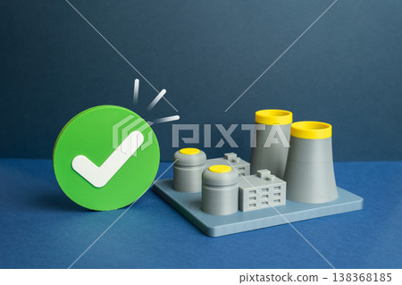 A nuclear power plant with an approval sign confirms safety compliance. Radiation levels remain controlled and stable. Regulatory assessment ensures secure energy production, environmental protection. 138368185