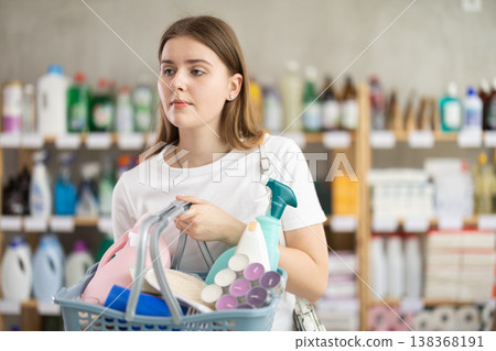 Young woman chooses household chemicals in store Young woman chooses household chemicals in store 138368191