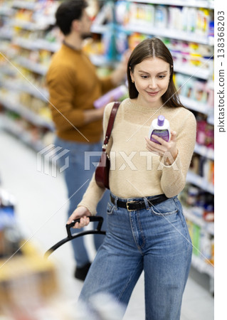 Woman spends time in store, looking for goods and select care product Woman spends time in store, looking for goods and select care product 138368203