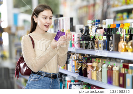 Woman spends time in store, looking for goods and select perfume Woman spends time in store, looking for goods and select perfume 138368225