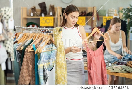 woman chooses a cotton dress against the background of a buyer 138368258