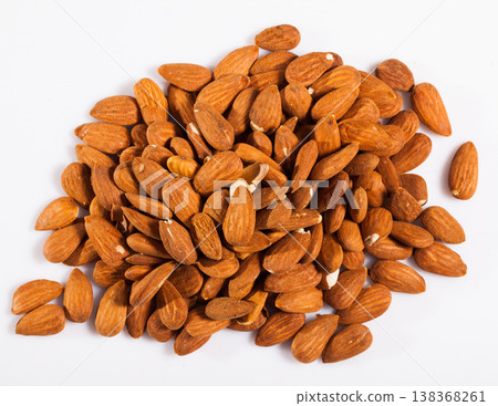 Handful of roasted almond nuts on a white surface Handful of roasted almond nuts on a white surface 138368261