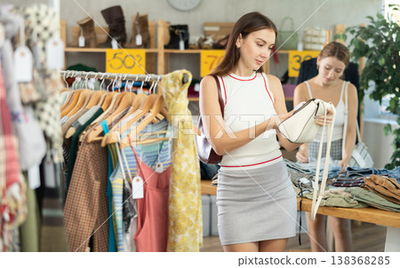 Woman checking price tag on handbag during shopping Woman checking price tag on handbag during shopping 138368285