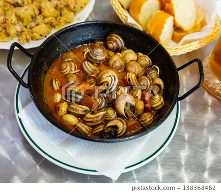Escargots. Appetizer of escargots stewed with chorizo served in black fry pan. Escargots. Appetizer of escargots stewed with chorizo served in black fry pan. 138368462