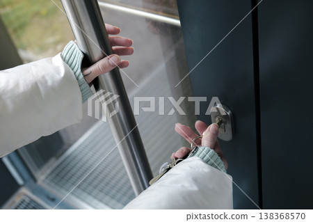 A person opening a door with a key creates a moment of transition from public to private space, comfort and familiarity. A person opening a door with a key creates a moment of transition from public to private space, comfort and familiarity. 138368570