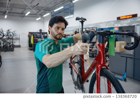 Experienced professional adjusting bicycle components meticulously in contemporary bike shop Experienced professional adjusting bicycle components meticulously in contemporary bike shop 138368720