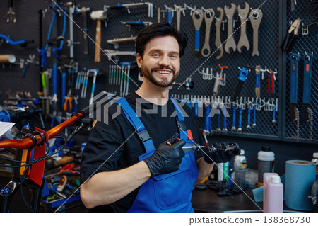 Customer-oriented repair expert presenting completed handlebar assembly with friendly demeanor Customer-oriented repair expert presenting completed handlebar assembly with friendly demeanor 138368730