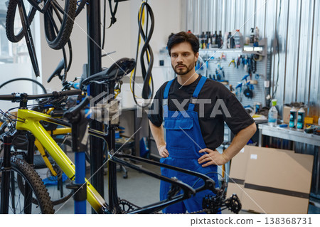 Workshop technician analyzing bicycle frame thoroughly 138368731