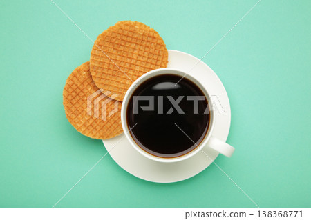 Traditional local authentic Dutch Netherlands sweet fresh homemade tasty stack brown golden waffle melt salted caramel with hot warm coffee. Stroopwafel on mint background Traditional local authentic Dutch Netherlands sweet fresh homemade tasty stack brown golden waffle melt salted caramel with hot warm coffee. Stroopwafel on mint background 138368771