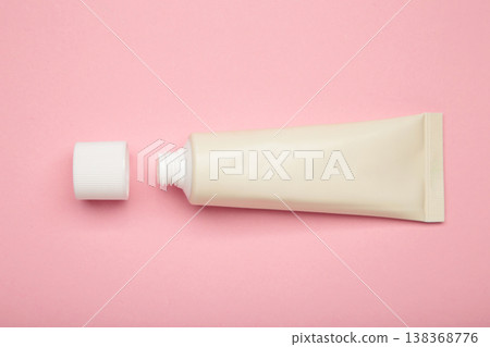 Beige tube of cream on pink background. Mockup plastic tube for cosmetics Beige tube of cream on pink background. Mockup plastic tube for cosmetics 138368776
