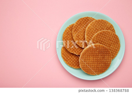 Dutch waffles stroopwafel syrup waffle caramel waffle on plate on pink background Dutch waffles stroopwafel syrup waffle caramel waffle on plate on pink background 138368788