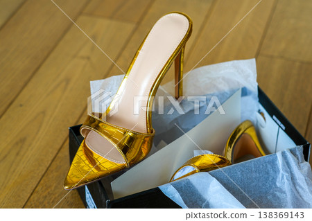 Golden sexy high heel slip on shoes in box, luxury fashion footwear on wooden floor display Golden sexy high heel slip on shoes in box, luxury fashion footwear on wooden floor display 138369143
