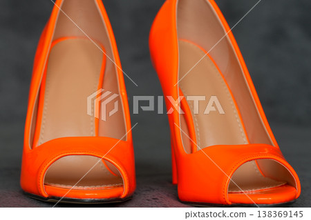 Pair of bright orange high heel shoes close up glossy elegant fashion footwear studio shot Pair of bright orange high heel shoes close up glossy elegant fashion footwear studio shot 138369145