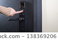 A woman opens a modern smart door lock with a digital keypad using a code. 138369206