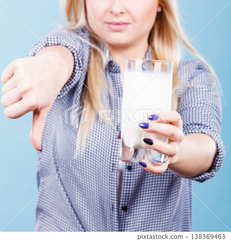 Woman holding milk glass showing thumb down Woman holding milk glass showing thumb down 138369463