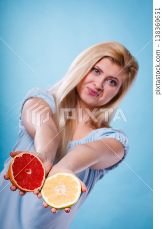 Woman holds grapefruit citrus fruit in hands 138369651