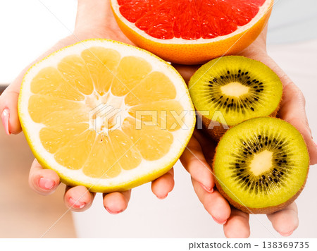 Woman holding fruits kiwi. orange, lemon and grapefruit 138369735