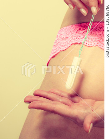 Girl holding tampon during the monthly cycle Girl holding tampon during the monthly cycle 138369766