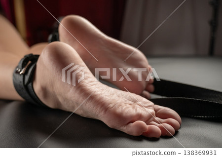 Women's legs in leather shackles. BDSM fetish. 138369931