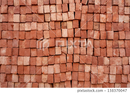 Stack of red bricks arranged end-on, close-up texture background for construction industry Stack of red bricks arranged end-on, close-up texture background for construction industry 138370047