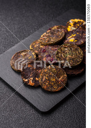 Organic Chinese green pu-erh tea with various herbs in round bricks. Chinese pu-erh tea Organic Chinese green pu-erh tea with various herbs in round bricks. Chinese pu-erh tea 138370069