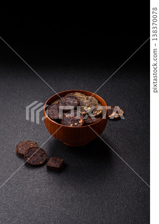 Organic Chinese green pu-erh tea with various herbs in round bricks. Chinese pu-erh tea Organic Chinese green pu-erh tea with various herbs in round bricks. Chinese pu-erh tea 138370078