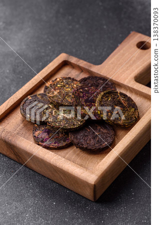 Organic Chinese green pu-erh tea with various herbs in round bricks. Chinese pu-erh tea Organic Chinese green pu-erh tea with various herbs in round bricks. Chinese pu-erh tea 138370093